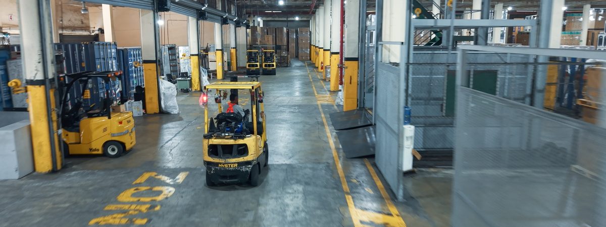 Central warehouse aisle with forklifts in operation