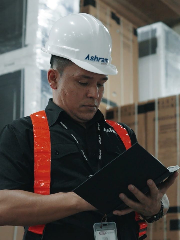 Ashram Logistics supervisor reviewing cargo documentation in the warehouse