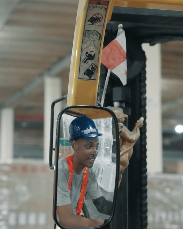 Forklift operator reflected in the vehicle’s rear-view mirror
