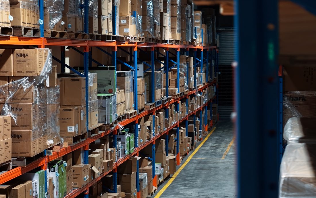 Racking aisle holding appliance inventory in the Ashram Logistics warehouse